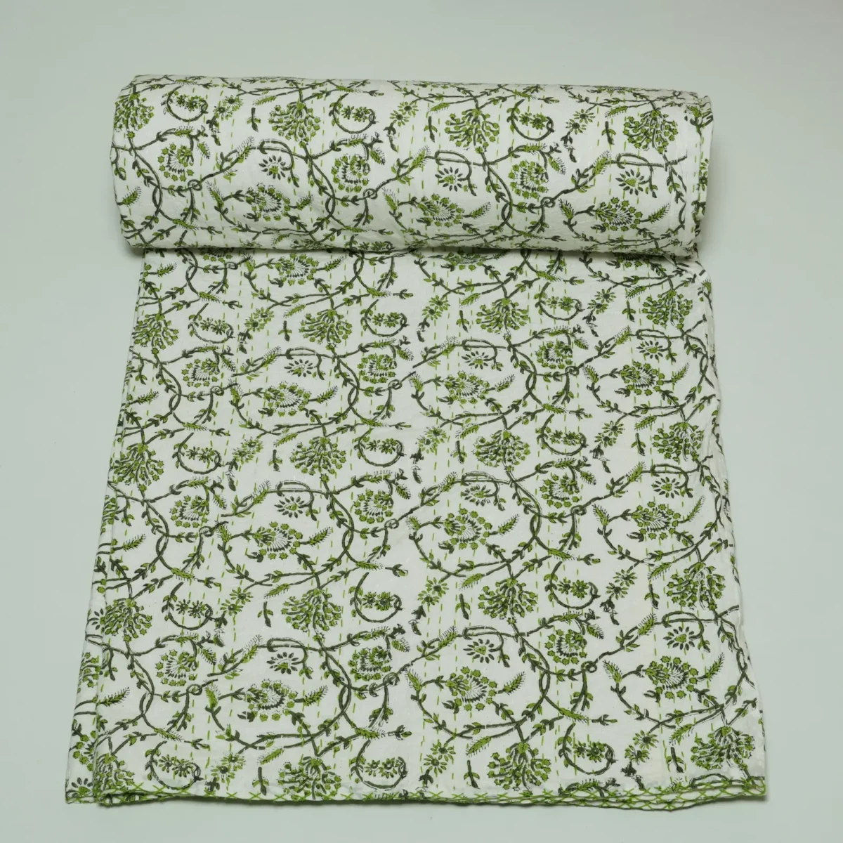 “Handmade green floral block print Kantha quilt on white cotton fabric with hand stitching”