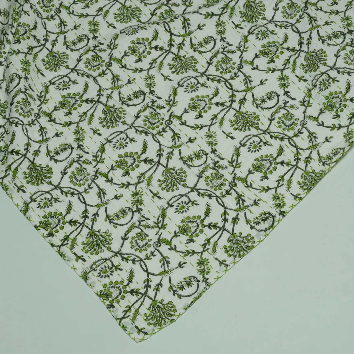 “Handmade green floral block print Kantha quilt on white cotton fabric with hand stitching”
