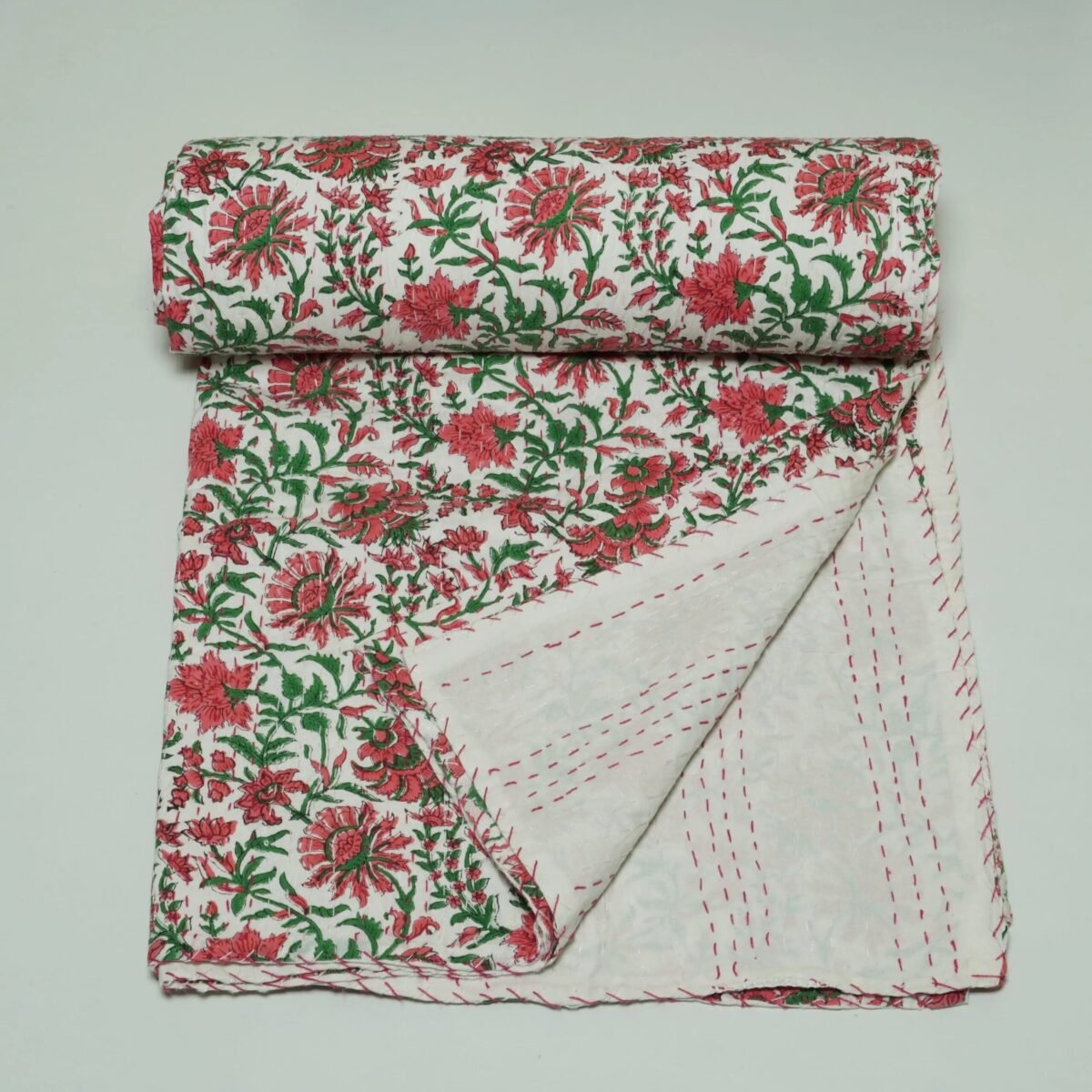 White floral block print Kantha quilt made from pure cotton, featuring red floral patterns with green leaves, handmade and reversible bedspread