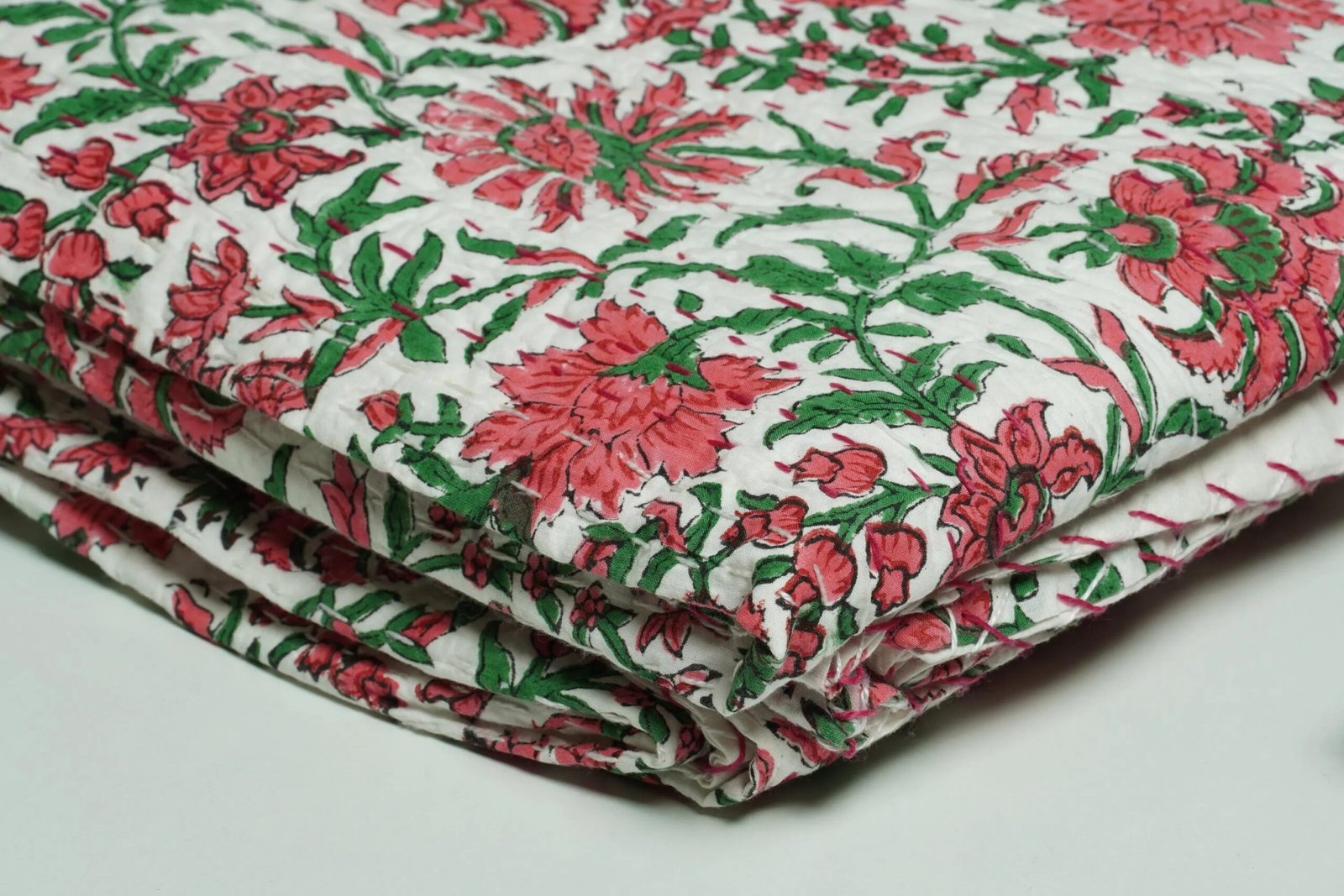White floral block print Kantha quilt made from pure cotton, featuring red floral patterns with green leaves, handmade and reversible bedspread